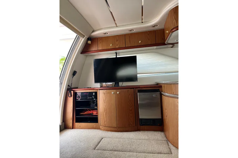 Slide: The Image of Interior of 1999 Maxum 4600 SCB yacht with TV, cabinets, and mini fridge. - 6
