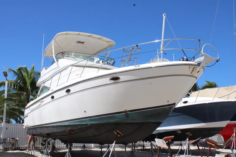 Slide: The Image of 1999 Maxum 4600 SCB yacht on stands, clear blue sky background. - 1