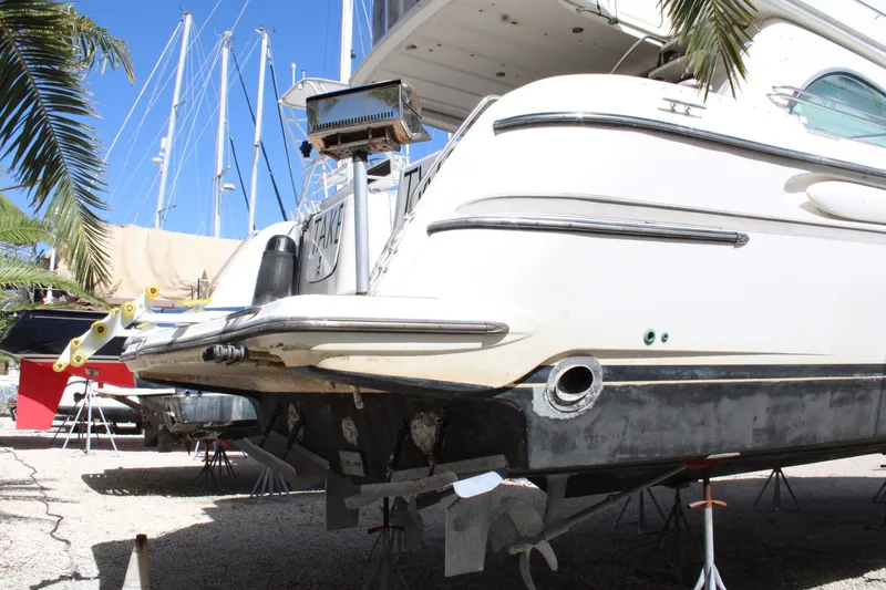Slide: The Image of 1999 Maxum 4600 SCB yacht on stands, undergoing maintenance in a marina. - 3