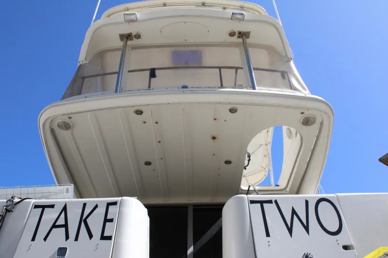 Slide: The Image of 1999 Maxum 4600 SCB yacht, rear view, with "Take Two" text, under clear blue sky. - 4