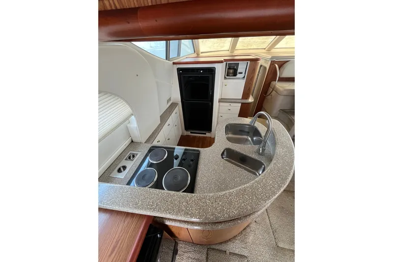 Slide: The Image of 1999 Maxum 4600 SCB yacht kitchen with stove, sink, and modern appliances. - 10