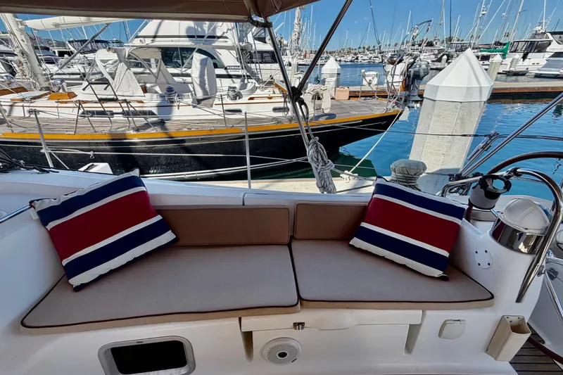 Slide: The Image of 2008 Jeanneau Sun Odyssey 49 DS yacht cockpit with striped cushions, docked in a marina. - 25