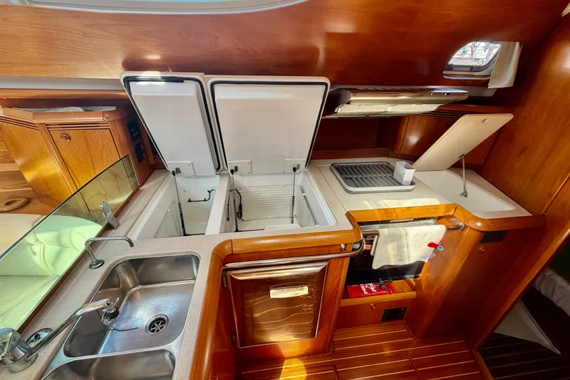 Slide: The Image of Galley kitchen in 2008 Jeanneau Sun Odyssey 49 DS yacht with wood finish and modern amenities. - 56