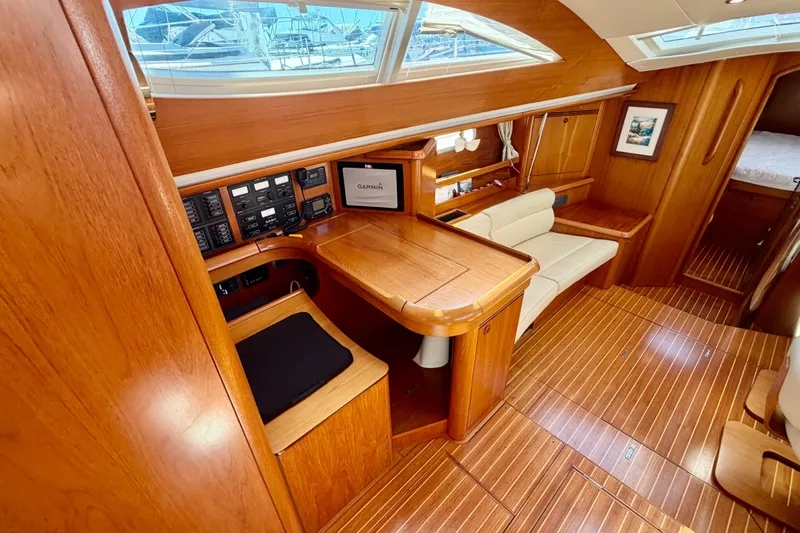 Slide: The Image of Luxurious interior of 2008 Jeanneau Sun Odyssey 49 DS sailboat with wood finish and navigation station. - 47