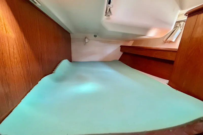 Slide: The Image of Interior cabin of 2008 Jeanneau Sun Odyssey 49 DS sailboat, featuring wooden paneling and a bed. - 77