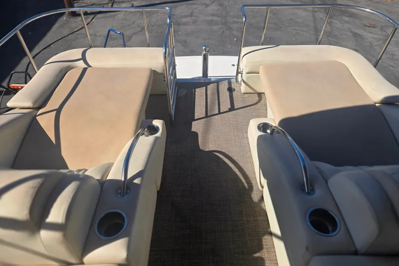 Slide: The Image of 2014 Bennington 2875 QCW I/O boat interior with beige seating and cup holders. - 6