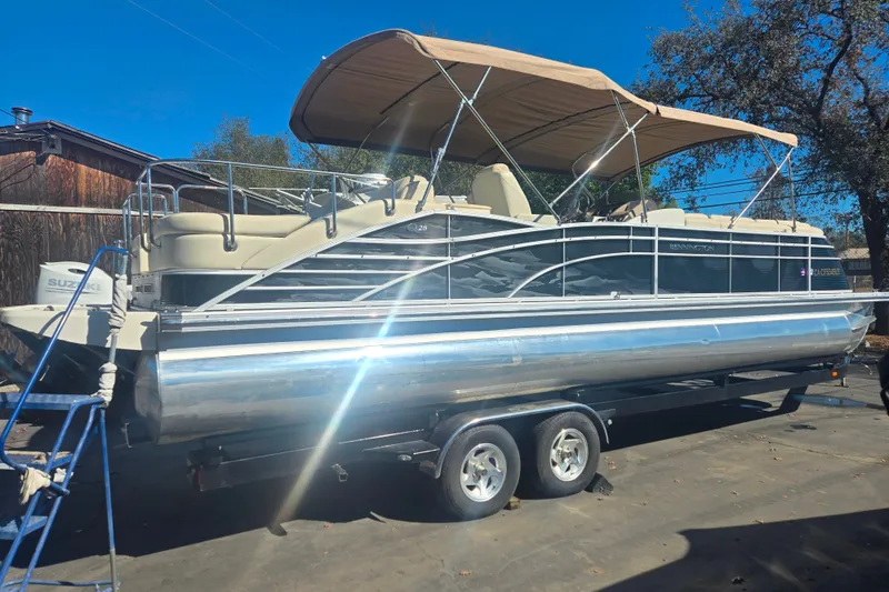 Slide: The Image of 2014 Bennington 2875 QCW I/O pontoon boat on trailer, with canopy and Suzuki engine. - 13