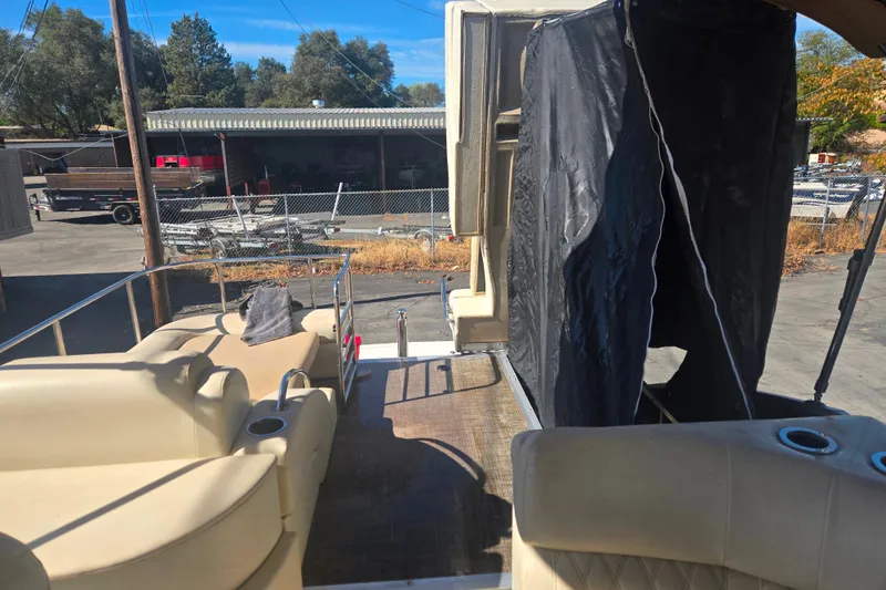 Slide: The Image of 2014 Bennington 2875 QCW I/O boat interior with beige seating and outdoor setting. - 4