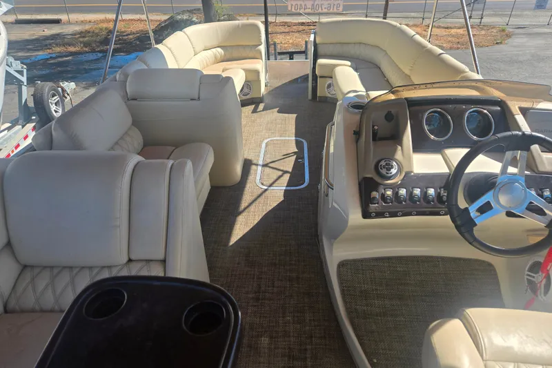 Slide: The Image of 2014 Bennington 2875 QCW I/O boat interior with beige seating and steering console. - 7