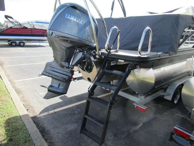 Slide: The Image of A Bennington 22 MFB pontoon boat with a Yamaha outboard motor, parked on a trailer. - 8