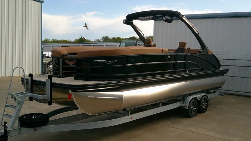 Slide: The Image of A 2027 Bennington M 26 pontoon boat on a trailer in a storage area. - 5