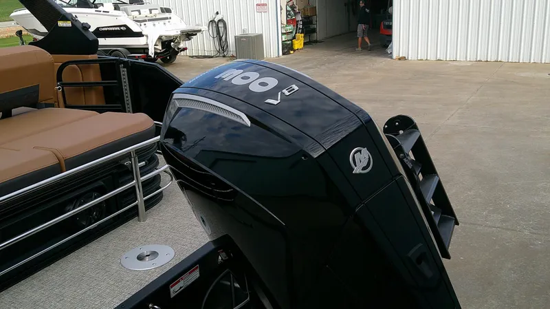 Slide: The Image of A modern outboard motor on a boat, situated on a concrete floor in front of a warehouse. - 7