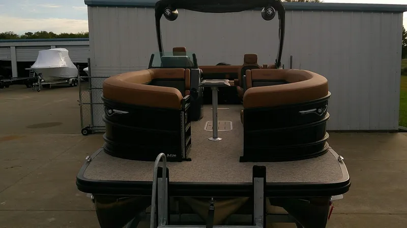 Slide: The Image of The image shows a Bennington M 26 pontoon boat with brown seating and a central table. - 4