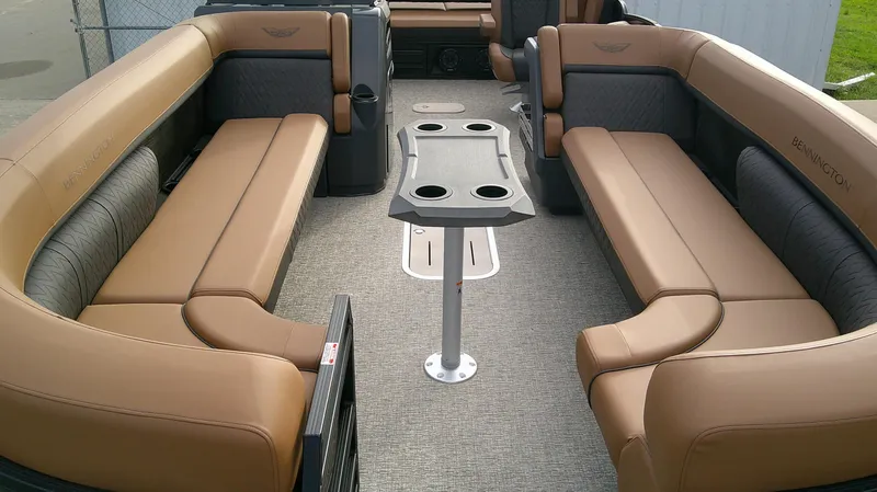 Slide: The Image of Interior of a Bennington M 26 with beige and gray upholstery and a table with cup holders. - 10