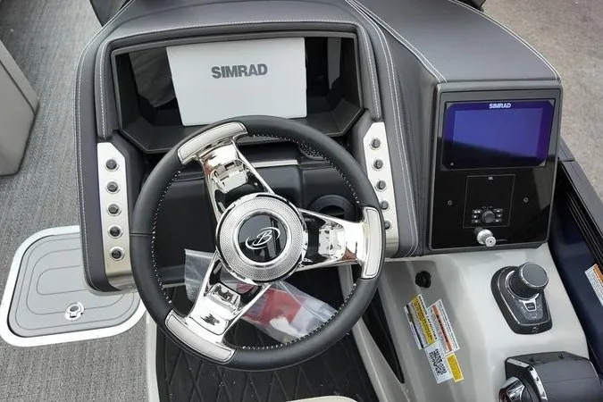 Slide: The Image of 2025 Barletta LUSSO 25UCAT boat dashboard with Simrad navigation system and sleek steering wheel. - 11