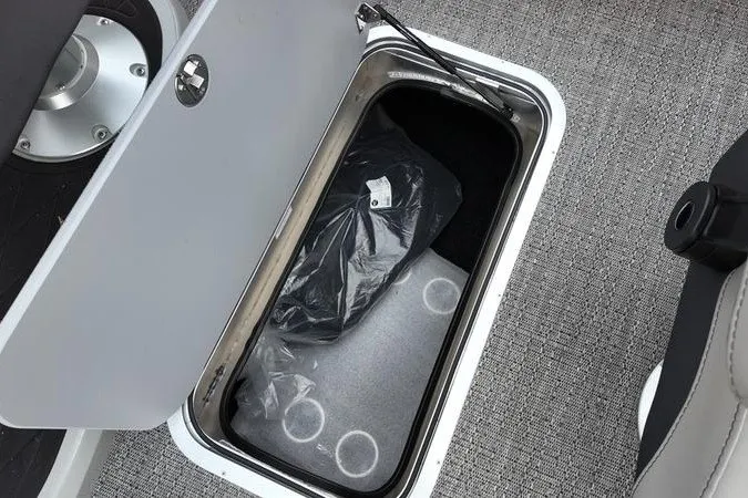 Slide: The Image of Storage compartment in 2025 Barletta LUSSO 25UCAT boat, featuring secure latch and interior space. - 9