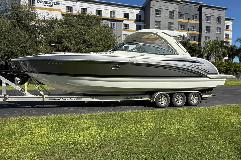 Slide: The Image of 2020 Formula 350 Crossover Bowrider on trailer, parked near a hotel. - 2