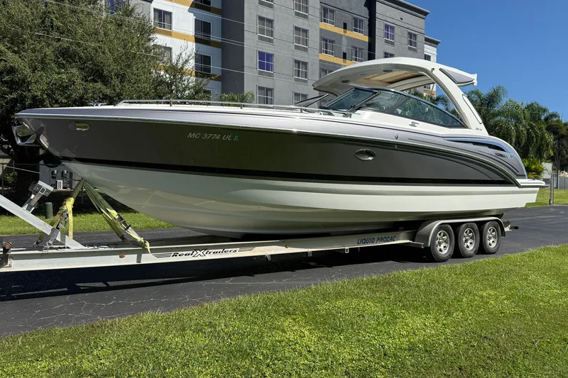 Slide: The Image of 2020 Formula 350 Crossover Bowrider on trailer, parked outdoors near modern building. - 1