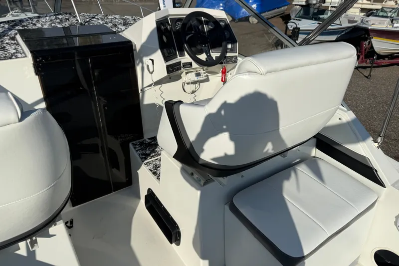 Slide: The Image of 1991 Carver 25 Montego boat cockpit with white seating and steering wheel. - 7