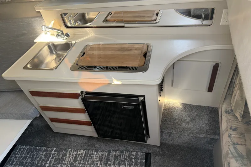 Slide: The Image of Compact kitchen area in a 1991 Carver 25 Montego boat with sink and stove. - 12