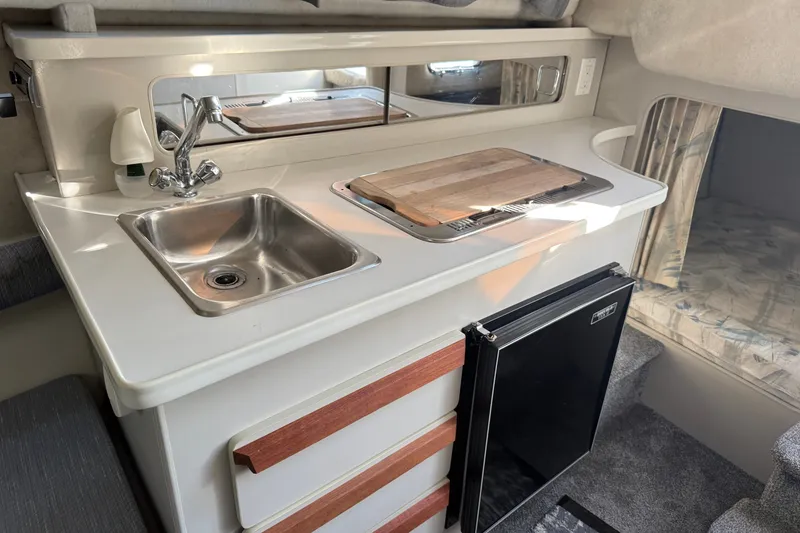 Slide: The Image of Compact kitchen area in a 1991 Carver 25 Montego boat with sink and mini fridge. - 17
