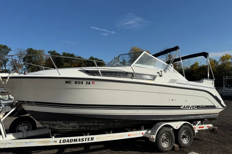 Slide: The Image of 1991 Carver 25 Montego boat on trailer under clear blue sky. - 1