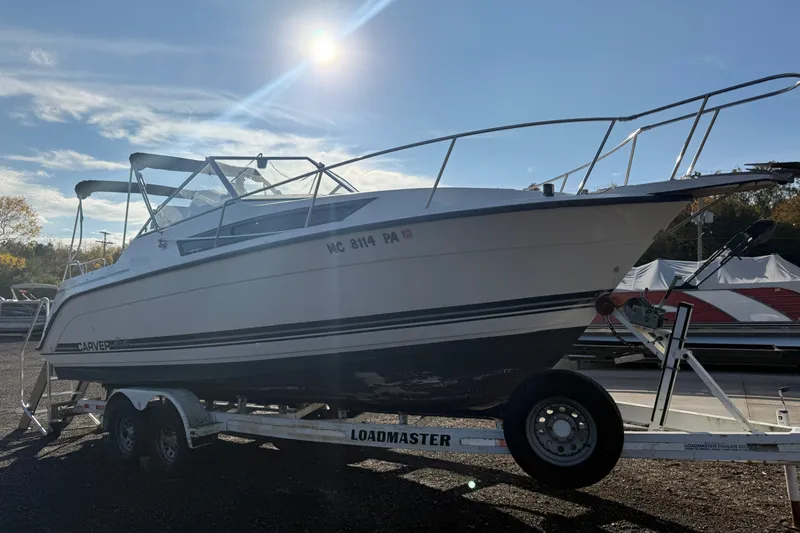 Slide: The Image of 1991 Carver 25 Montego boat on trailer under bright sun. - 3