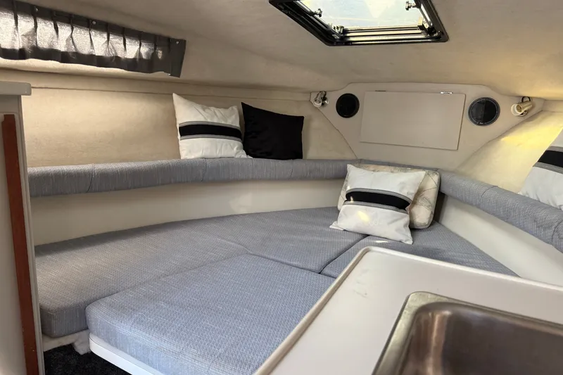 Slide: The Image of Interior cabin of a 1991 Carver 25 Montego boat with cozy seating and pillows. - 16