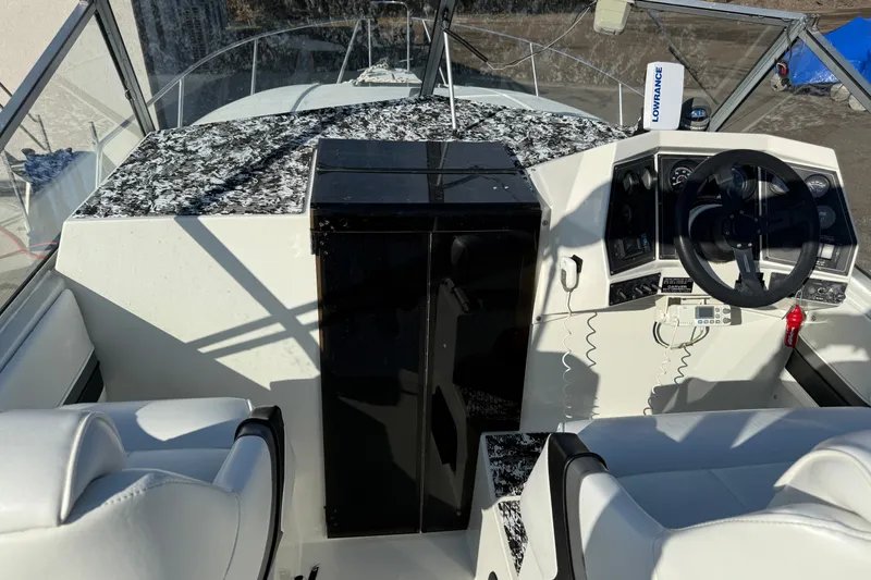 Slide: The Image of 1991 Carver 25 Montego boat cockpit with steering wheel and control panel. - 10