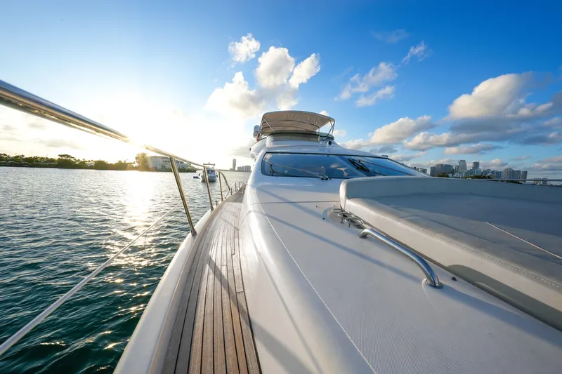 Slide: The Image of 2007 Azimut 68E yacht cruising on calm waters at sunset, with city skyline in background. - 73