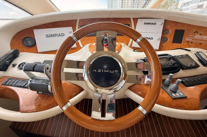 Slide: The Image of Steering wheel of a 2007 Azimut 68E yacht with navigation controls and Simrad displays. - 32