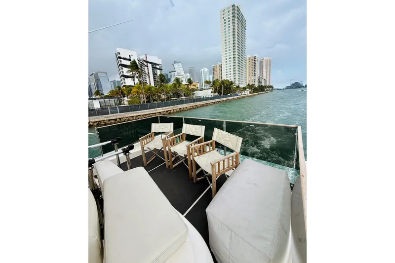 Slide: The Image of 2007 Azimut 68E yacht deck with chairs, city skyline, and waterfront view. - 81
