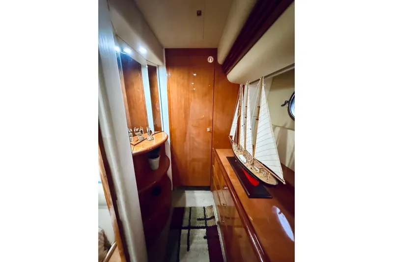Slide: The Image of Luxurious interior of 2007 Azimut 68E yacht with elegant wood finishes and model sailboat. - 54