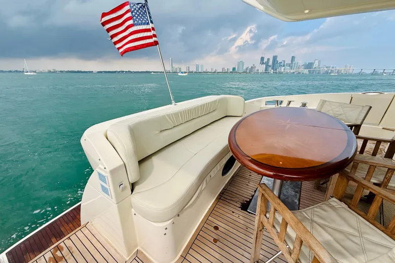 Slide: The Image of Luxury Azimut 68E yacht deck with seating, table, and American flag, 2007 model. - 60