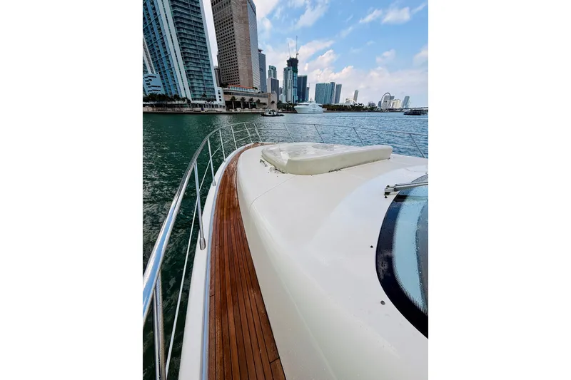Slide: The Image of 2007 Azimut 68E yacht cruising near city skyline, wooden deck, clear sky. - 67