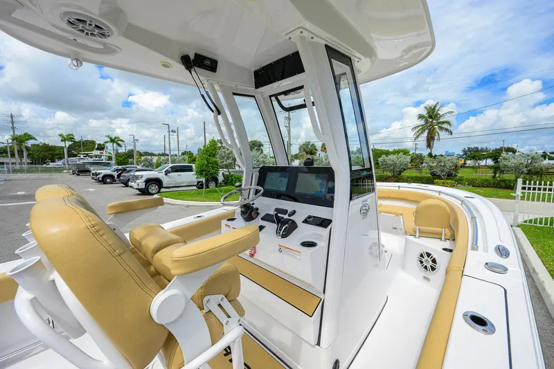 Slide: The Image of 2024 Sportsman Open 232 Center Console boat interior with tan seating and modern controls. - 31