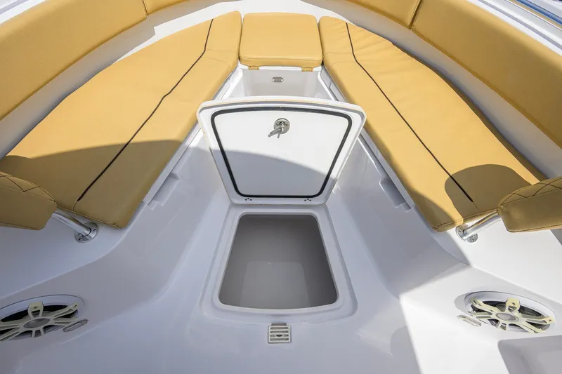 Slide: The Image of 2024 Sportsman Open 232 Center Console boat interior with tan cushions and storage compartment. - 22