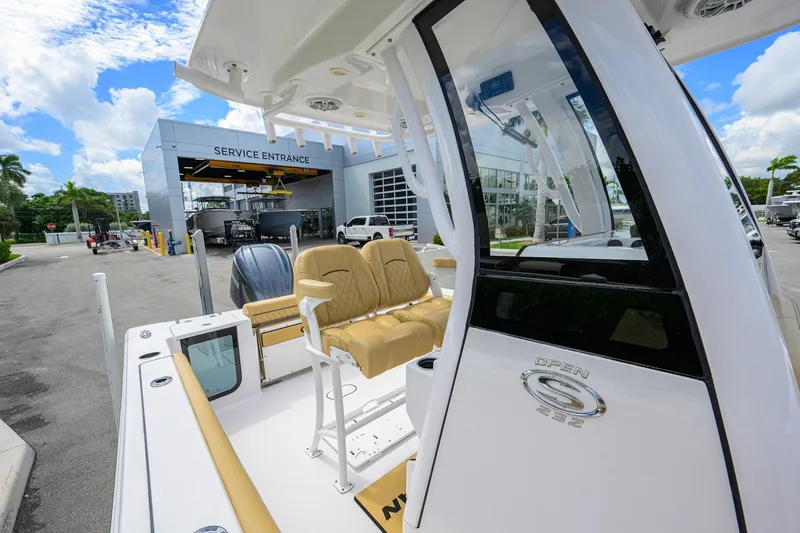 Slide: The Image of 2024 Sportsman Open 232 Center Console boat at service entrance, featuring tan seating. - 35