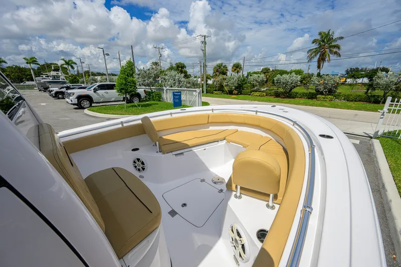 Slide: The Image of 2024 Sportsman Open 232 Center Console boat with tan seating, parked outdoors. - 24