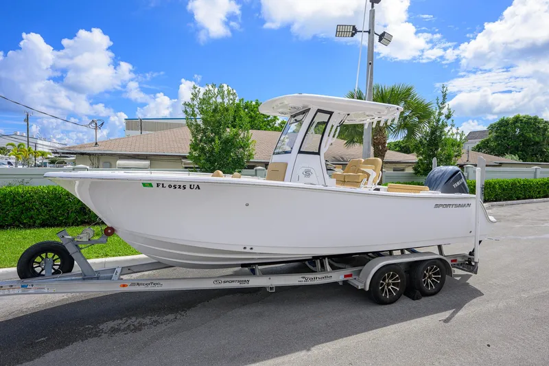 Slide: The Image of 2024 Sportsman Open 232 Center Console boat on trailer, parked outdoors under a clear sky. - 1