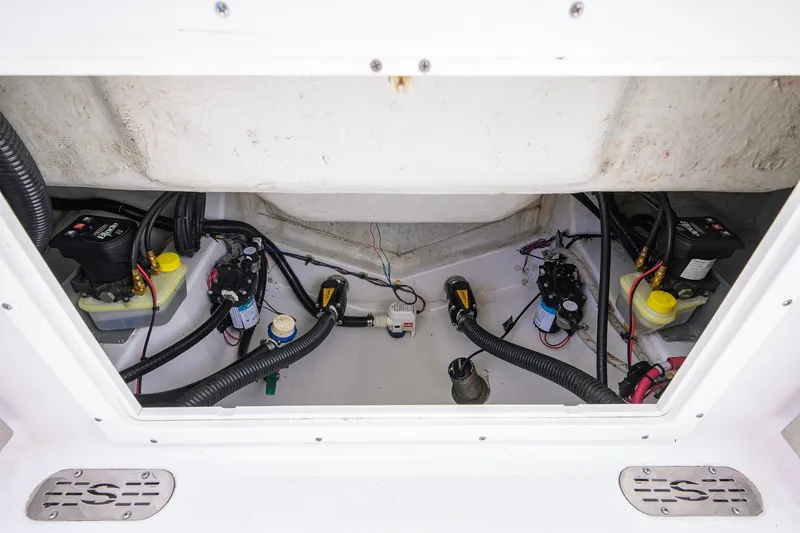 Slide: The Image of 2024 Sportsman Open 232 Center Console boat wiring and components in storage compartment. - 49