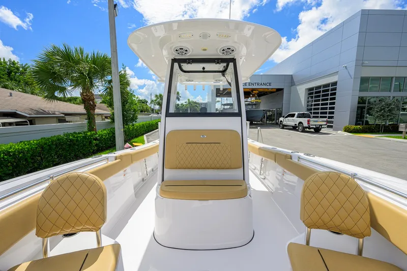 Slide: The Image of 2024 Sportsman Open 232 Center Console boat with tan seating, parked outdoors. - 19