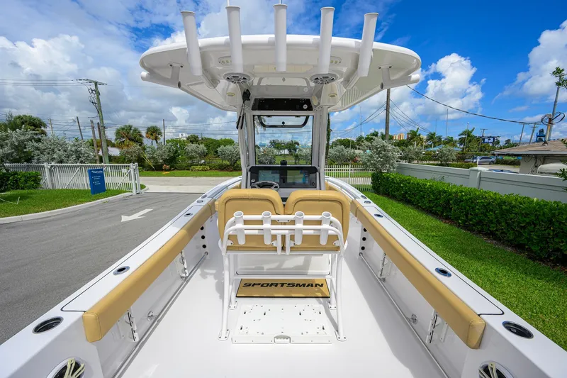 Slide: The Image of 2024 Sportsman Open 232 Center Console boat with tan seating, docked outdoors. - 38
