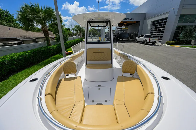 Slide: The Image of 2024 Sportsman Open 232 Center Console boat with tan seating, docked outdoors. - 18