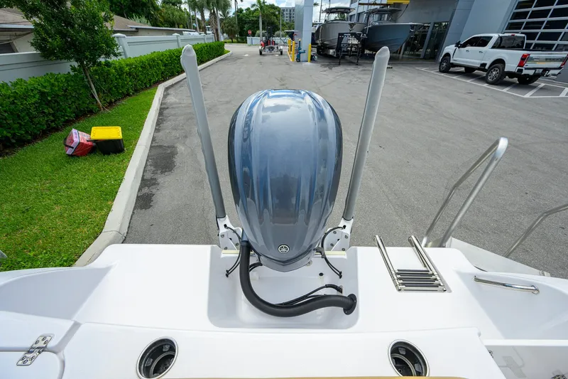 Slide: The Image of 2024 Sportsman Open 232 Center Console boat with outboard motor in a parking area. - 13