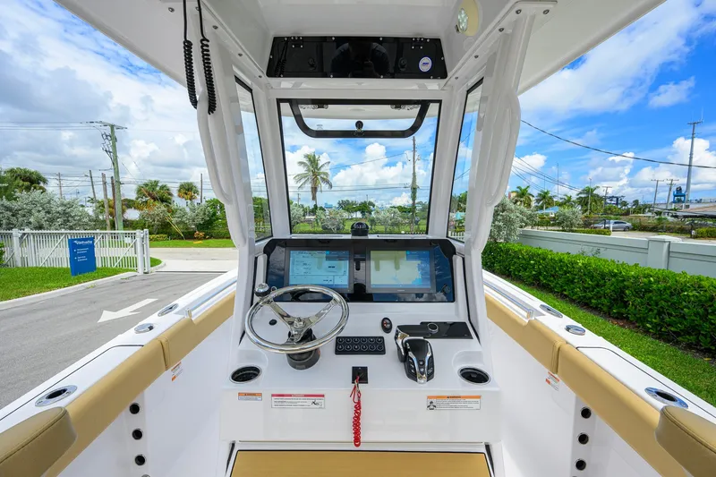 Slide: The Image of 2024 Sportsman Open 232 Center Console boat interior with steering wheel and navigation screens. - 2