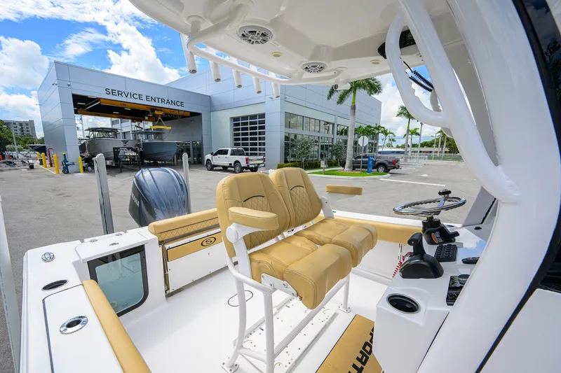 Slide: The Image of 2024 Sportsman Open 232 Center Console boat at service entrance, showcasing helm and seating. - 34