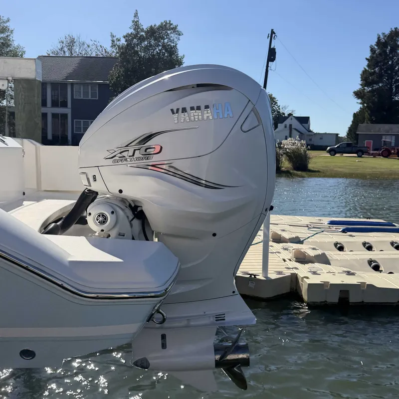 Slide: The Image of A Yamaha outboard motor on a Cobia 330 Dual Console boat docked by the water. - 4