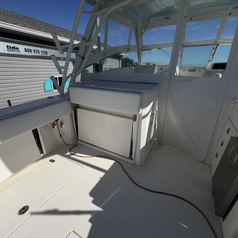 Slide: The Image of The image shows the cockpit of a 2023 Cobia 330 Dual Console boat with white seating. - 8