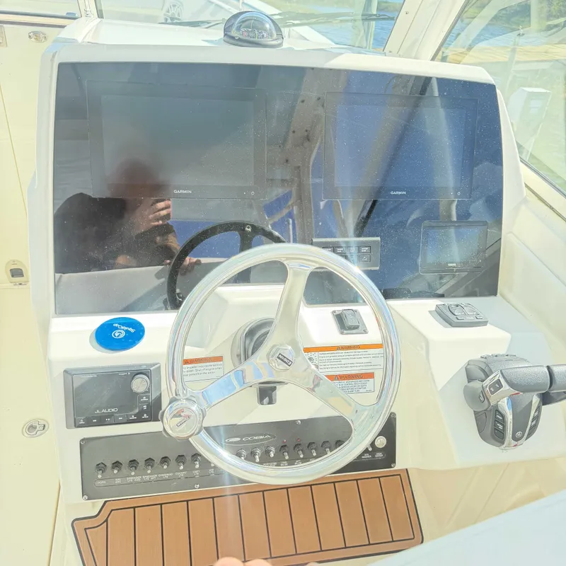 Slide: The Image of The image shows the helm of a 2023 Cobia 330 Dual Console boat with modern instruments. - 10